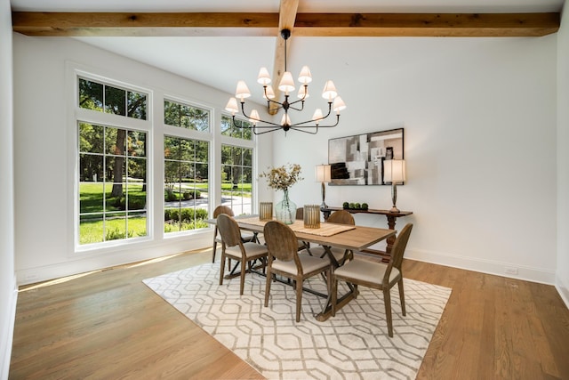 dining area featuring beamed ceiling, hardwood / wood-style flooring, and an inviting chandelier