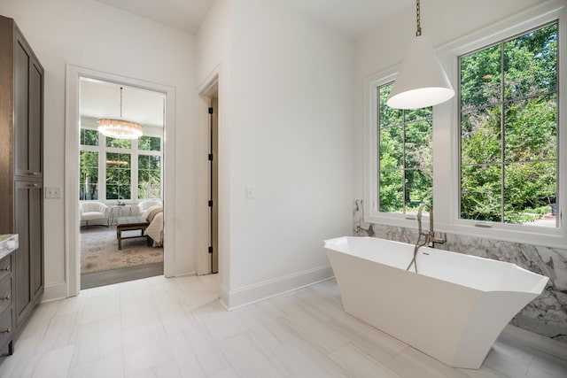 bathroom with an inviting chandelier and a bathing tub