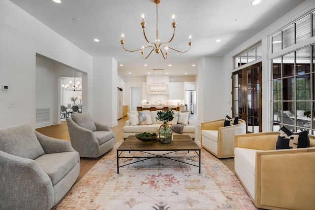 living room featuring a notable chandelier, light hardwood / wood-style floors, and sink