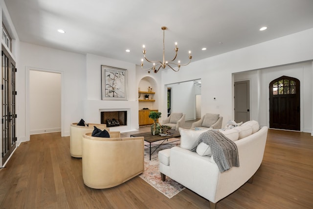 living room with dark hardwood / wood-style flooring, built in features, and a chandelier