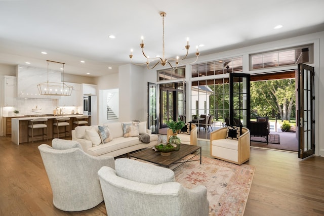 living room featuring light hardwood / wood-style floors, sink, and an inviting chandelier