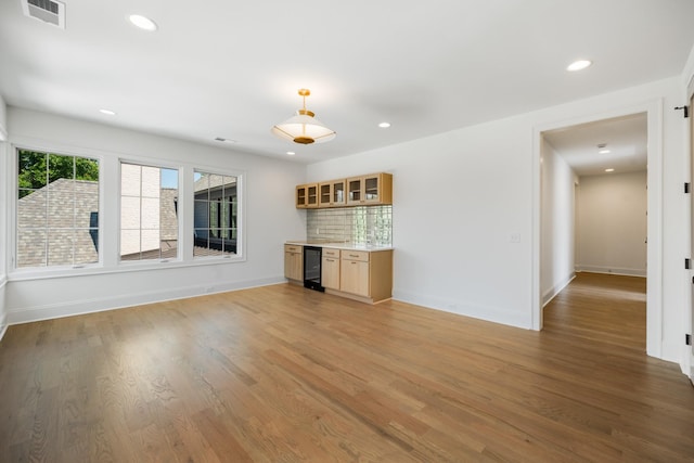 unfurnished living room with wine cooler and light hardwood / wood-style flooring