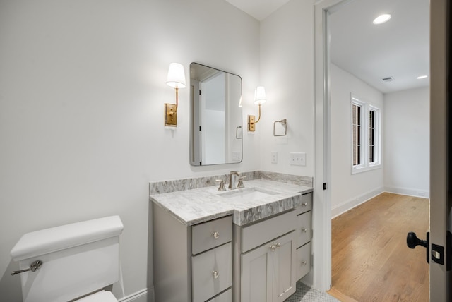 bathroom featuring hardwood / wood-style floors, vanity, and toilet