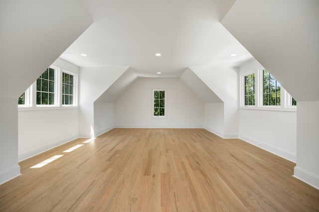 additional living space with vaulted ceiling and light wood-type flooring