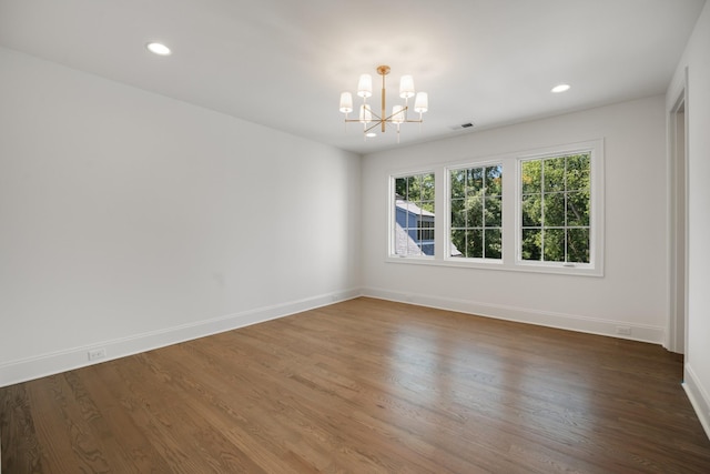 unfurnished room featuring dark hardwood / wood-style flooring and a chandelier