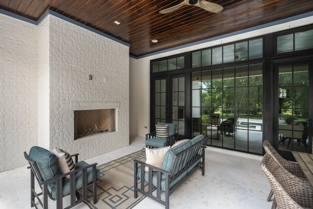 view of patio with ceiling fan and a large fireplace