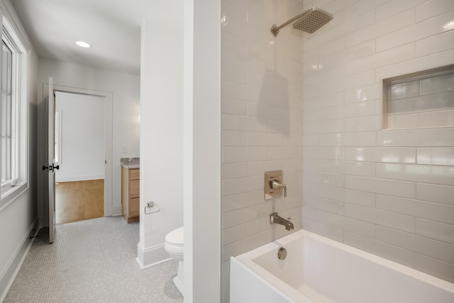 full bathroom featuring tile patterned flooring, tiled shower / bath combo, toilet, and vanity