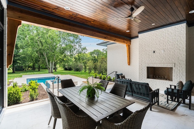 view of patio featuring ceiling fan and a fireplace