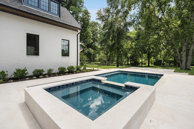 view of pool featuring an in ground hot tub and a patio