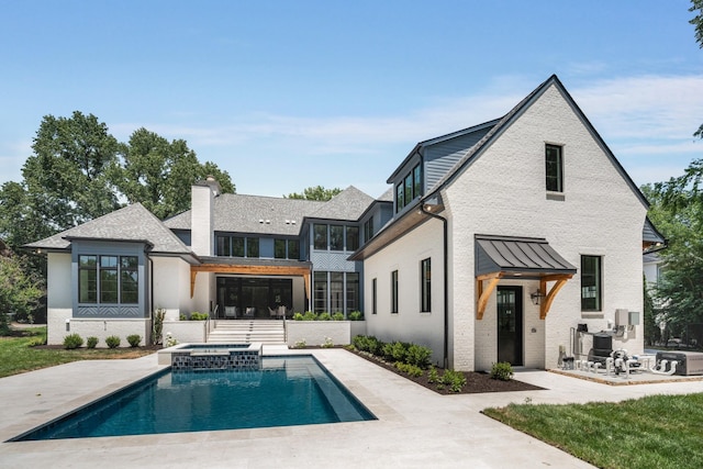 rear view of house with a pool with hot tub and a patio area