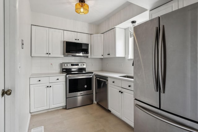 kitchen featuring tasteful backsplash, appliances with stainless steel finishes, and white cabinets