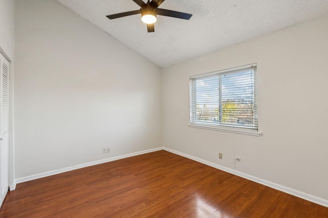 unfurnished room featuring lofted ceiling, ceiling fan, hardwood / wood-style flooring, and a textured ceiling