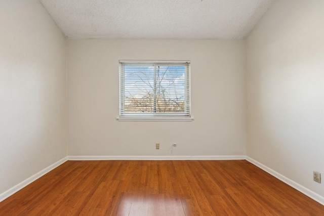 spare room featuring wood-type flooring and a textured ceiling