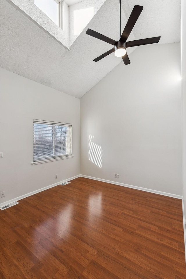 spare room featuring ceiling fan, hardwood / wood-style flooring, high vaulted ceiling, and a textured ceiling