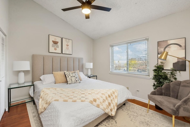 bedroom with lofted ceiling, hardwood / wood-style flooring, a closet, and a textured ceiling