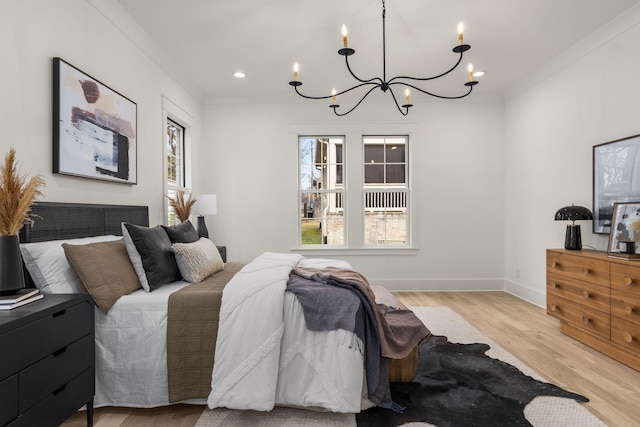 bedroom featuring light wood-type flooring, crown molding, and a chandelier