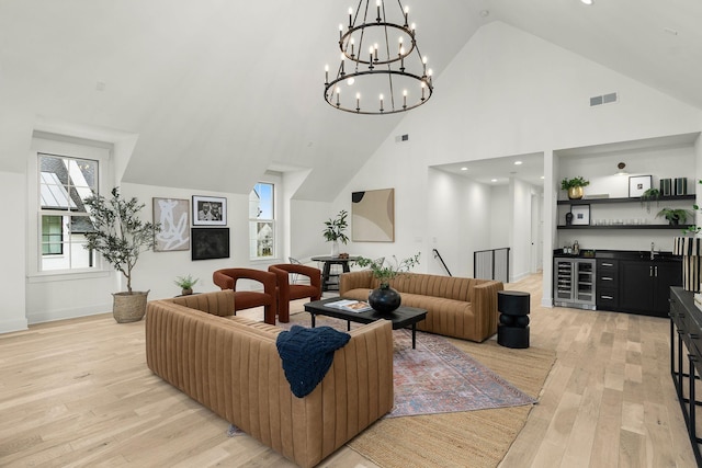 living room with light hardwood / wood-style flooring, wet bar, and a healthy amount of sunlight