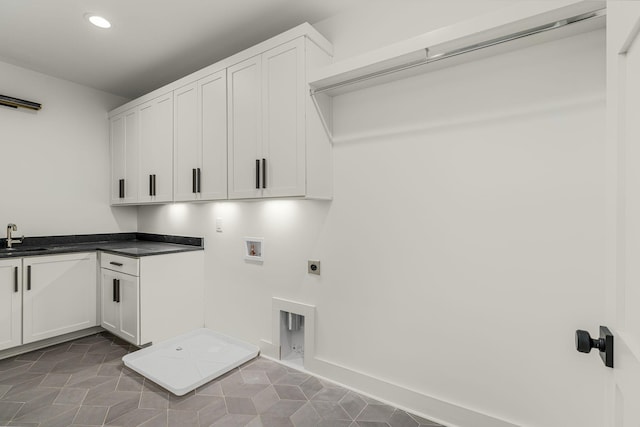 washroom featuring cabinets, washer hookup, dark tile patterned floors, electric dryer hookup, and sink