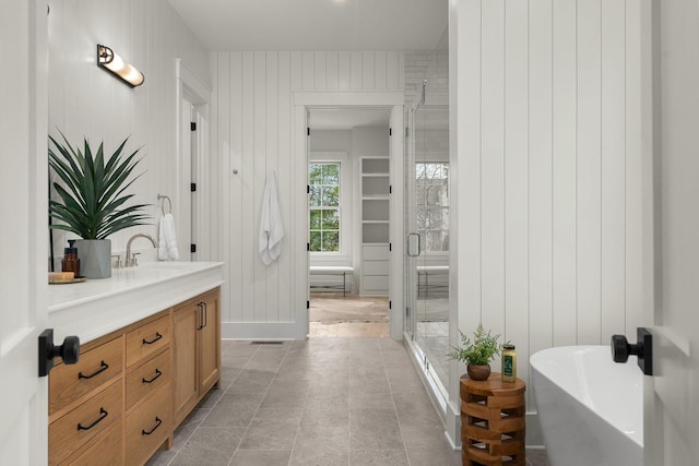 bathroom with vanity, separate shower and tub, and wood walls