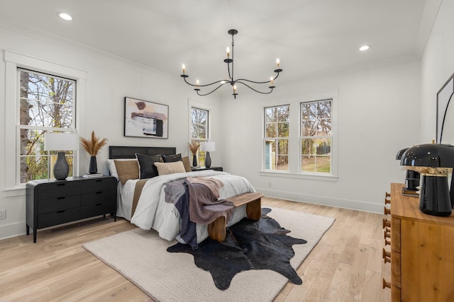 bedroom featuring light hardwood / wood-style flooring, a chandelier, and ornamental molding