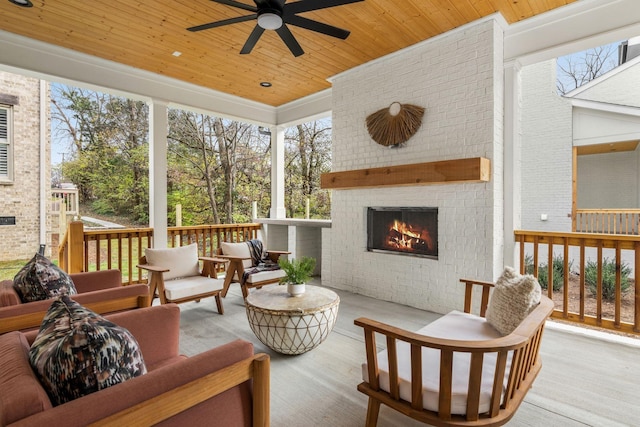 sunroom featuring an outdoor brick fireplace, ceiling fan, wooden ceiling, and a wealth of natural light