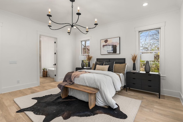 bedroom featuring crown molding, light hardwood / wood-style floors, and an inviting chandelier