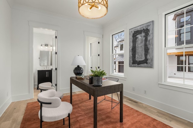 home office featuring plenty of natural light, wood-type flooring, and crown molding