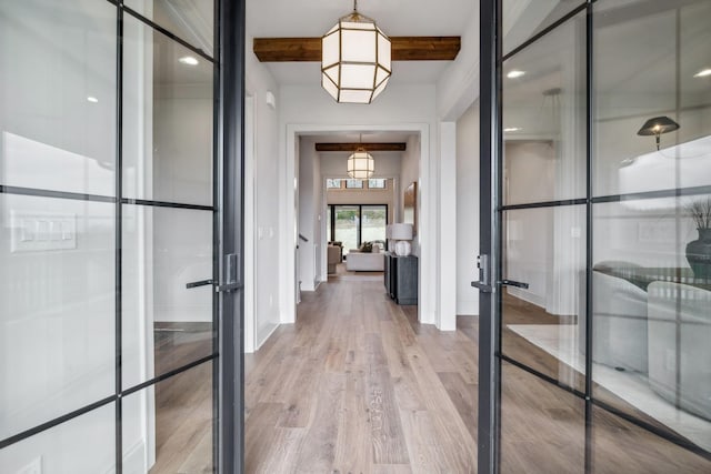 corridor with beam ceiling, french doors, and hardwood / wood-style flooring