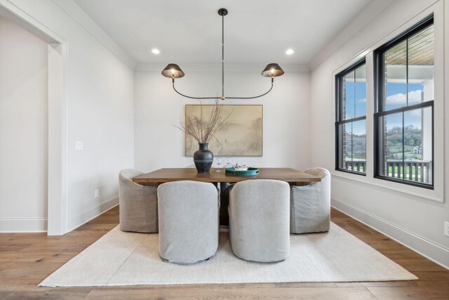 dining area with hardwood / wood-style floors and crown molding