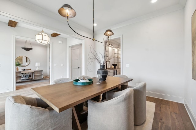 dining space with hardwood / wood-style flooring and ornamental molding