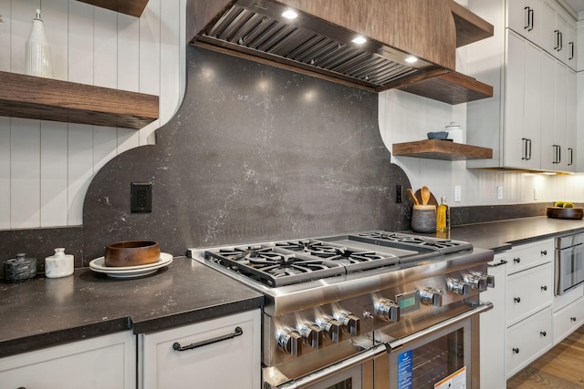 kitchen featuring custom exhaust hood, white cabinets, tasteful backsplash, wood-type flooring, and stainless steel appliances