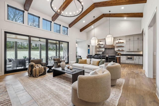 living room with a wealth of natural light, beamed ceiling, high vaulted ceiling, and light wood-type flooring