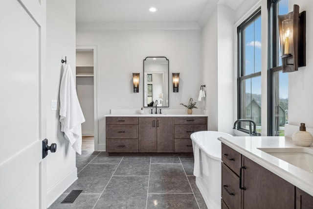 bathroom featuring a bath, vanity, and crown molding