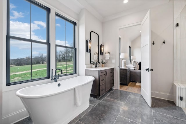 bathroom with vanity, crown molding, plenty of natural light, and a tub