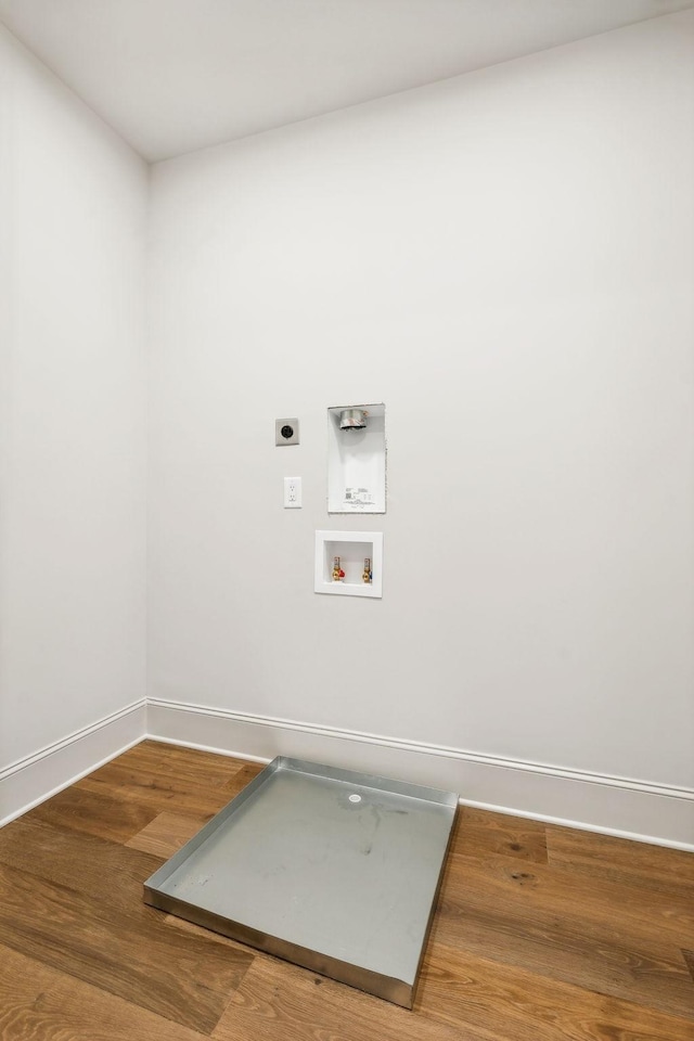 clothes washing area with hookup for an electric dryer, hookup for a washing machine, and hardwood / wood-style flooring