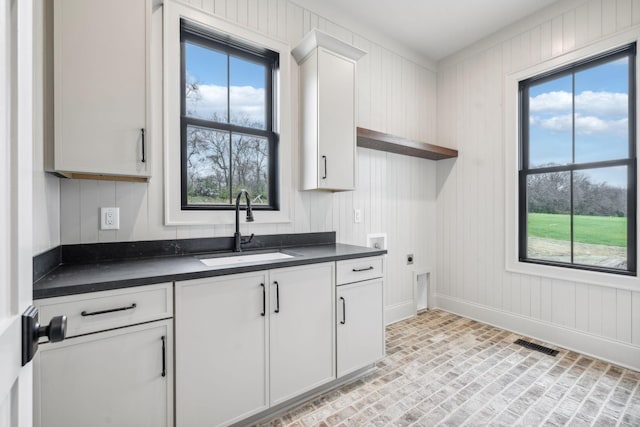 kitchen featuring white cabinets, a wealth of natural light, and sink