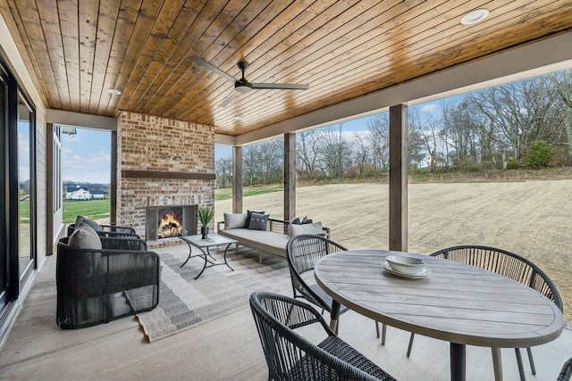 deck featuring an outdoor living space with a fireplace, ceiling fan, and a patio