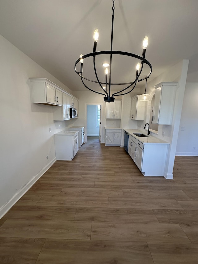 kitchen with sink, an inviting chandelier, dark hardwood / wood-style floors, black dishwasher, and white cabinets