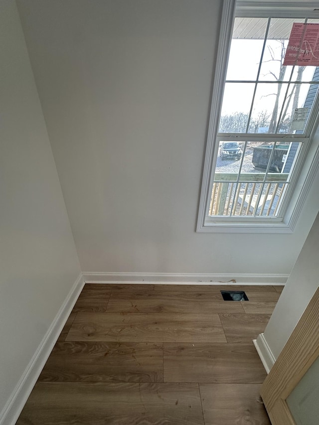 empty room with hardwood / wood-style flooring and a healthy amount of sunlight