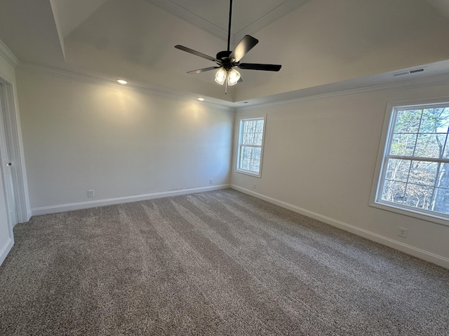 carpeted spare room with a tray ceiling, ornamental molding, and ceiling fan