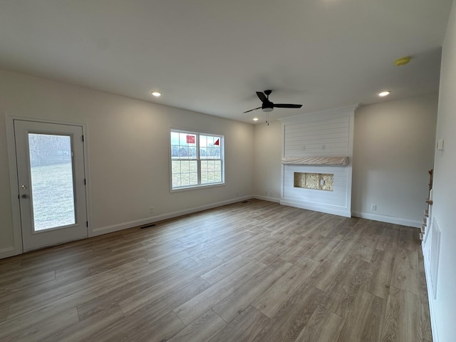 unfurnished living room with ceiling fan and light wood-type flooring