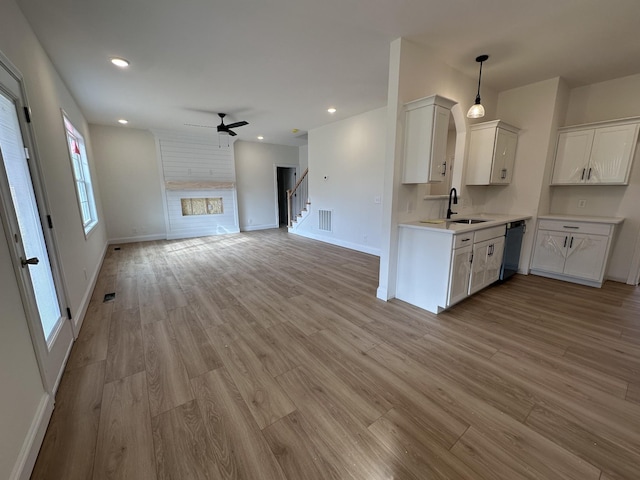 kitchen with dishwasher, sink, white cabinets, and light wood-type flooring