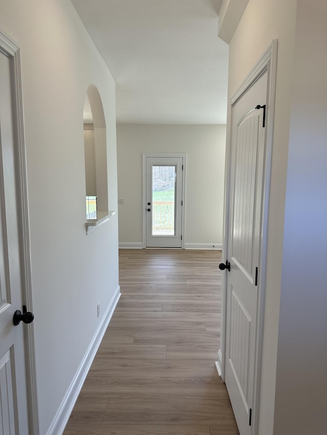 hallway with baseboards and wood finished floors