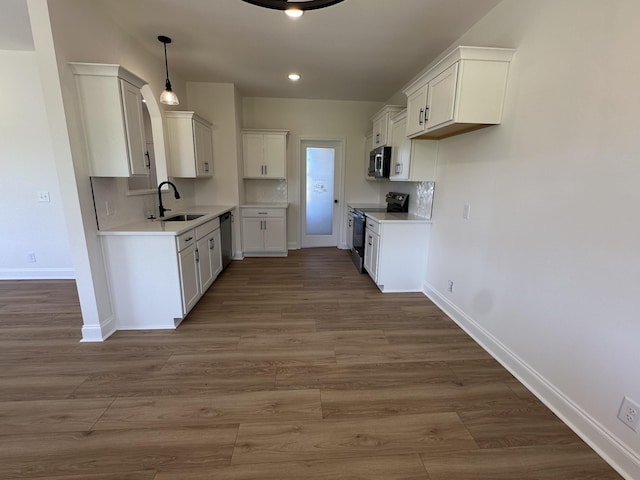 kitchen with stainless steel appliances, dark wood-type flooring, baseboards, backsplash, and a sink