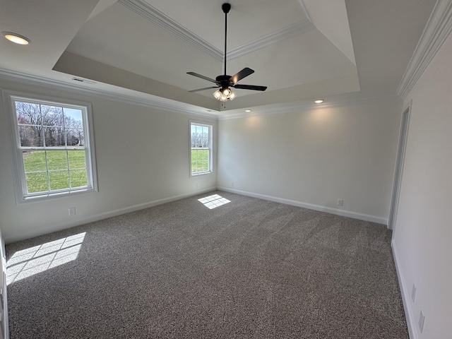 carpeted empty room with baseboards, crown molding, ceiling fan, and a raised ceiling