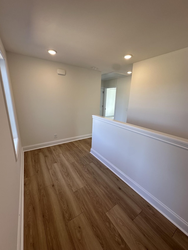 spare room with dark wood-type flooring, baseboards, recessed lighting, and attic access