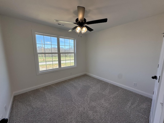 carpeted empty room with baseboards, visible vents, and a ceiling fan