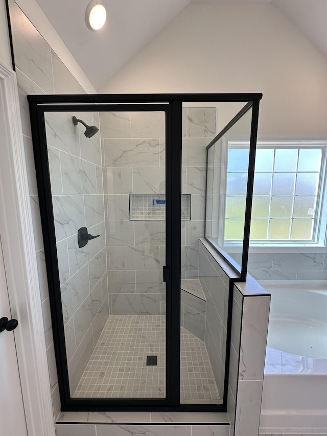 full bath with lofted ceiling, a garden tub, and a shower stall
