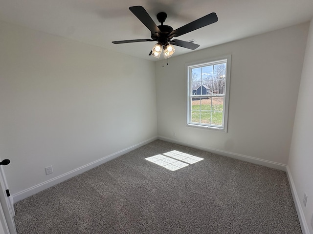 carpeted spare room with baseboards and ceiling fan