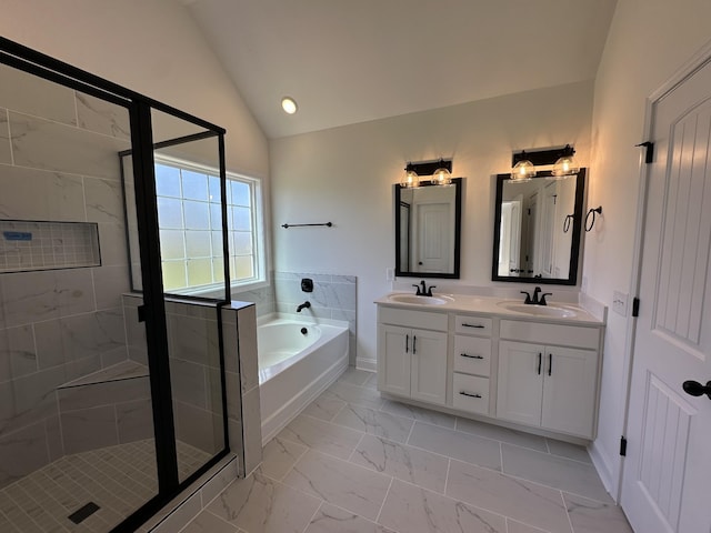 full bathroom featuring marble finish floor, a bath, lofted ceiling, and a sink